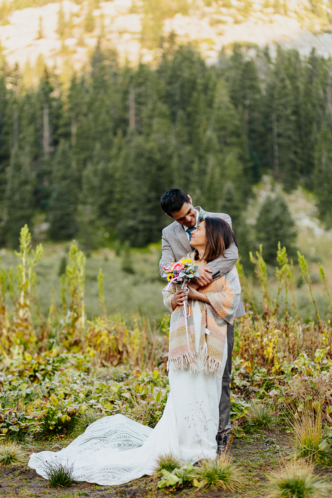 Anyeli and Alex wrapped in a warm embrace after their intimate sunrise elopement ceremony at Copper Lake in Crested Butte, Colorado.