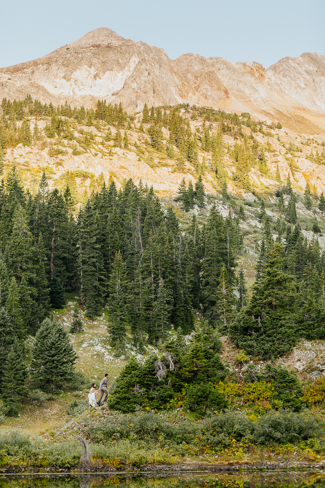 Anyeli and Alex hiking up a mountain trail in Crested Butte, preparing for their adventure elopement at Copper Lake.