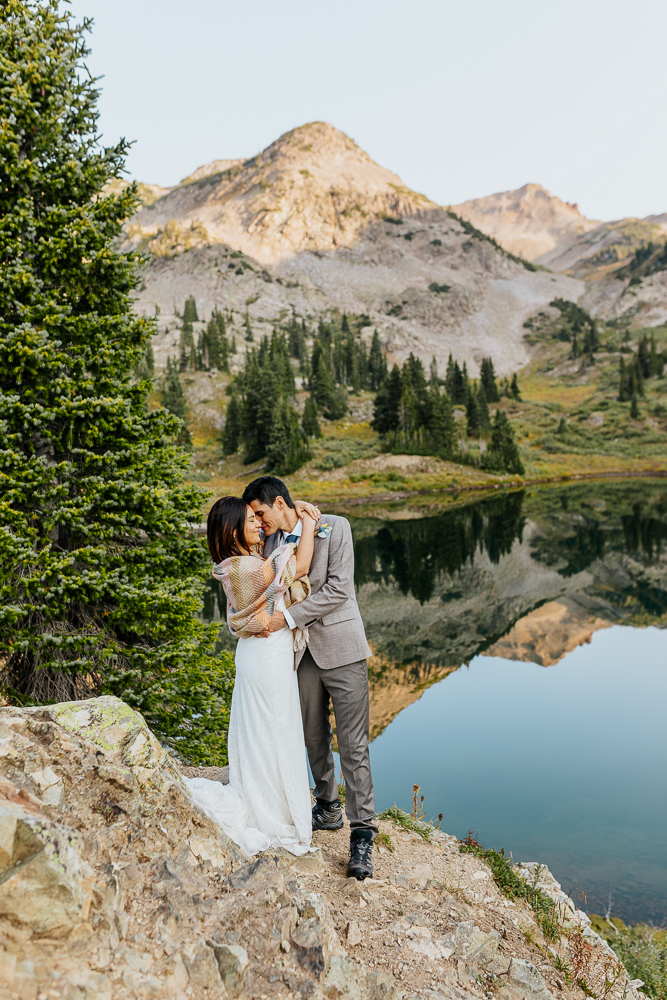 Anyeli and Alex sharing a tender moment with their foreheads touching during their sunrise elopement at Copper Lake, Crested Butte.