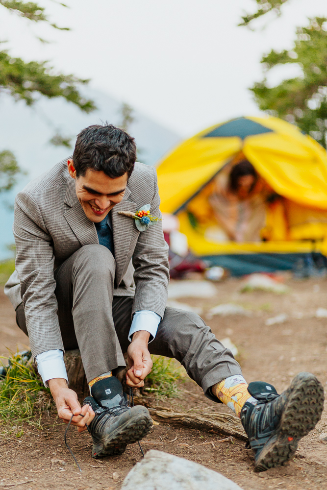 The groom lacing up his shoes before the sunrise elopement ceremony at Copper Lake, Crested Butte.