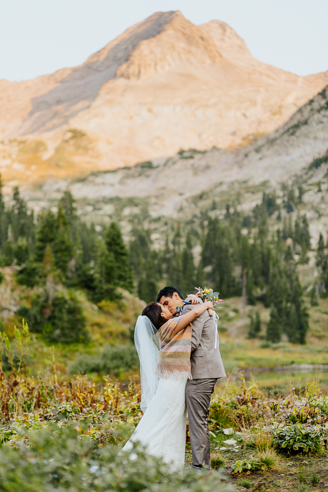 Anyeli and Alex kissing after exchanging vows during their intimate sunrise elopement ceremony at Copper Lake, Crested Butte, Colorado.