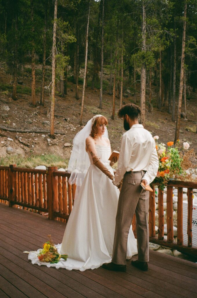 Film photo of the bride saying her vows on the porch of a Leadville cabin during their intimate Colorado elopement.