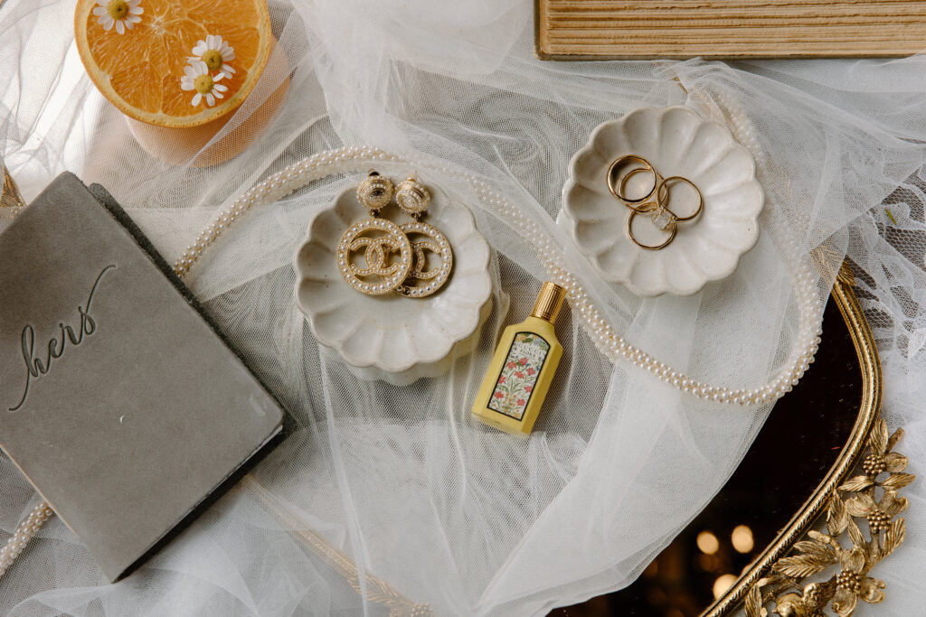 Artistic Colorado elopement bridal flatlay including wedding rings, oranges, shoes, veil, and coordinated detail pieces.