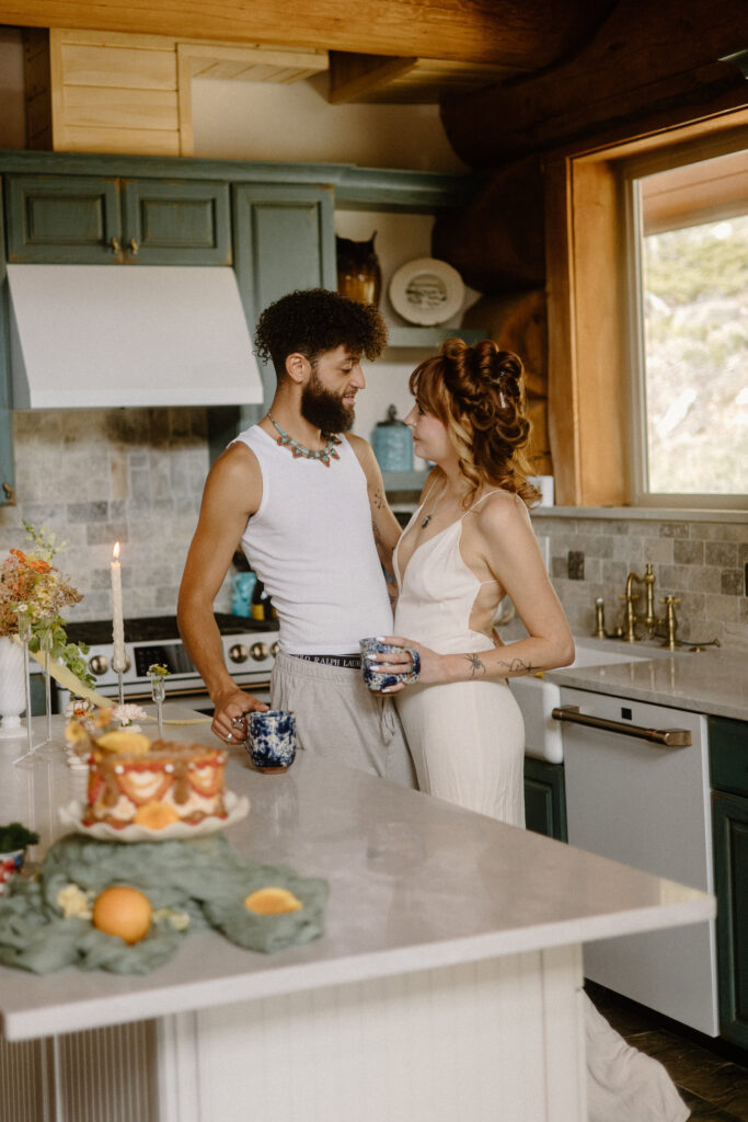 Outdoor-adventure couple sharing a cozy pajama moment in a rustic Colorado cabin before their elopement hike.
