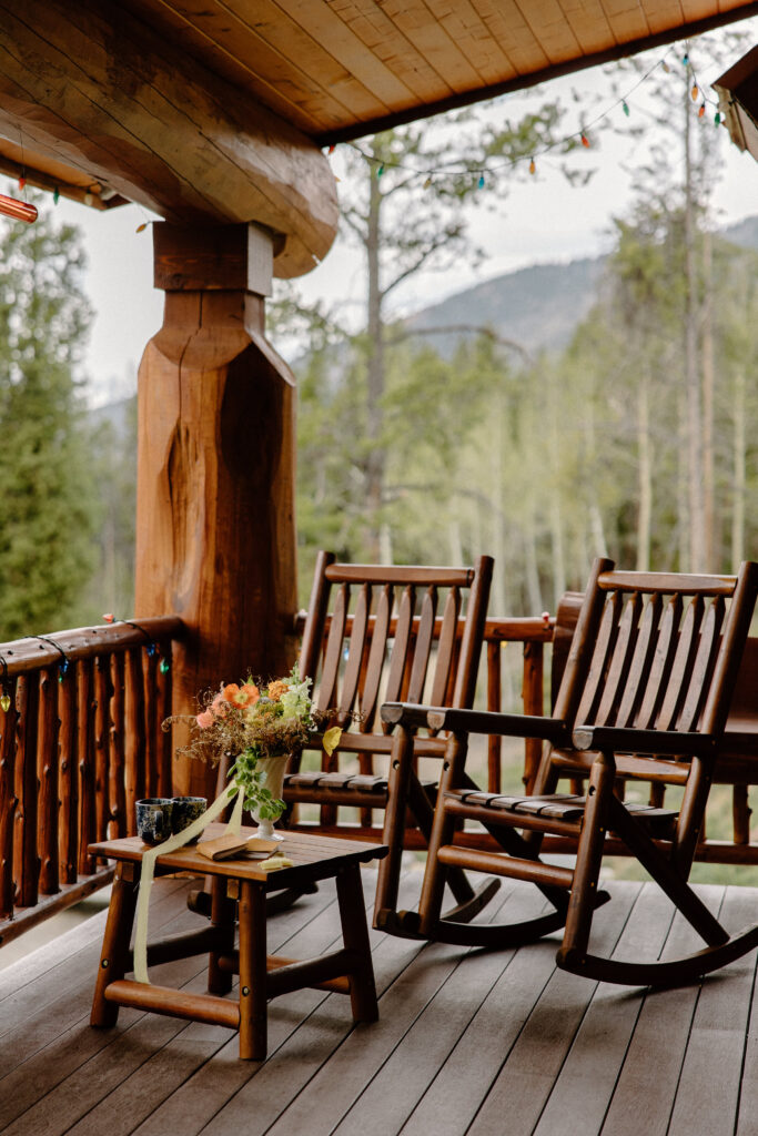 A bridal bouquet sits in front of two chairs at a cabin while the couple prepares for their Colorado elopement.