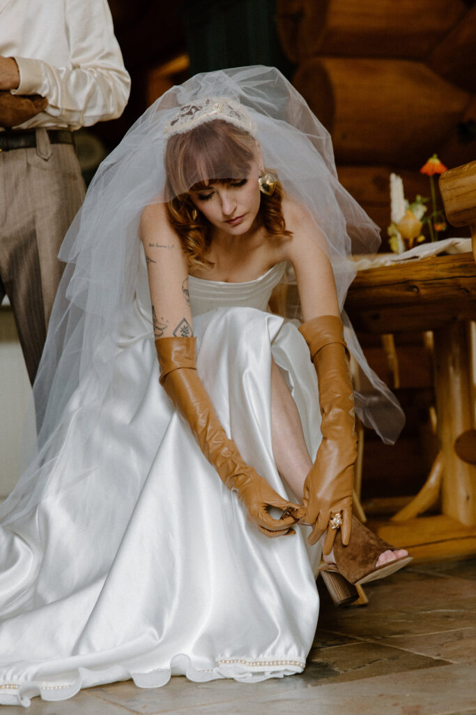 Colorado cabin bride slipping into her wedding shoes before an intimate elopement ceremony.