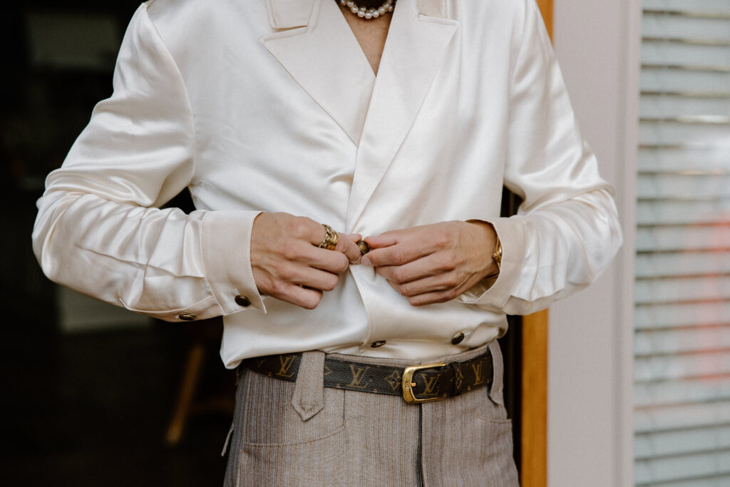 A groom adjusts the buttons on his dress shirt before his Colorado elopement.