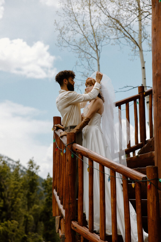 A groom lifts the veil off his bride's face during their first look before their elopement.