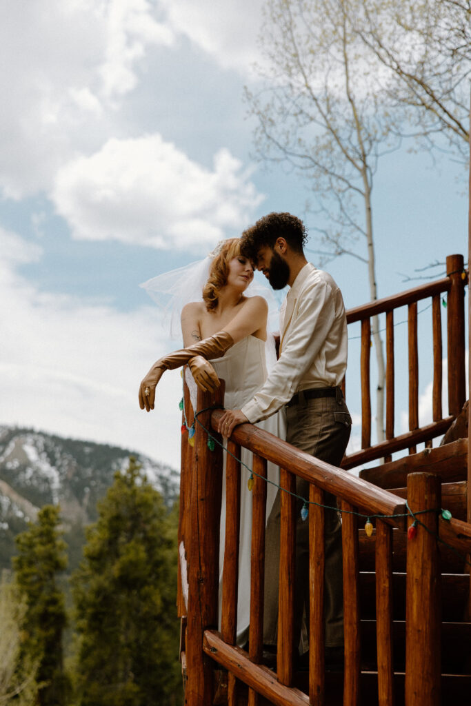 The couple touches foreheads in a tender, intimate moment during their Colorado cabin elopement.