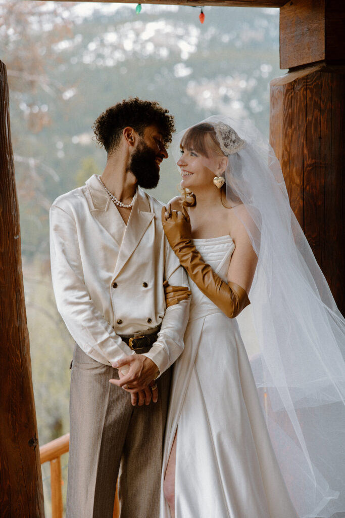 Adventure elopement moment with the couple looking at each other and smiling in the cozy cabin.