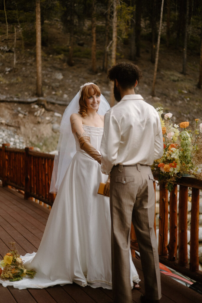 Adventure-loving couple exchanging personal vows during their cozy Colorado cabin elopement.