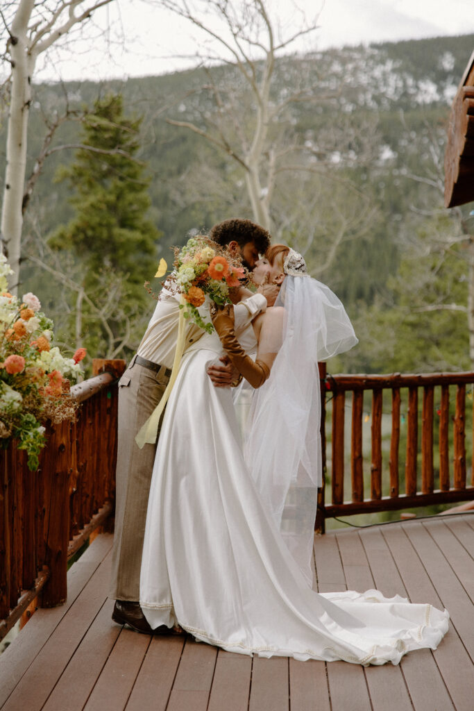 Colorado cabin elopement couple sharing a tender kiss in a warm, intimate setting.