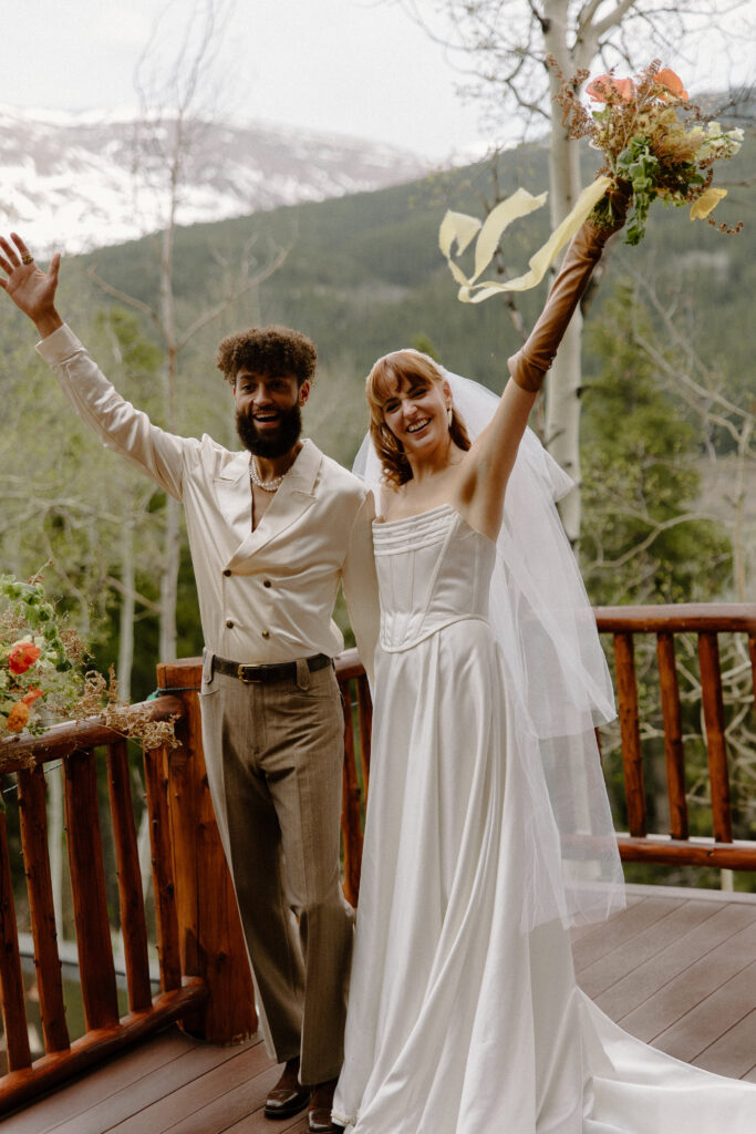 A couple cheers after their Colorado elopement in Leadville, Colorado.