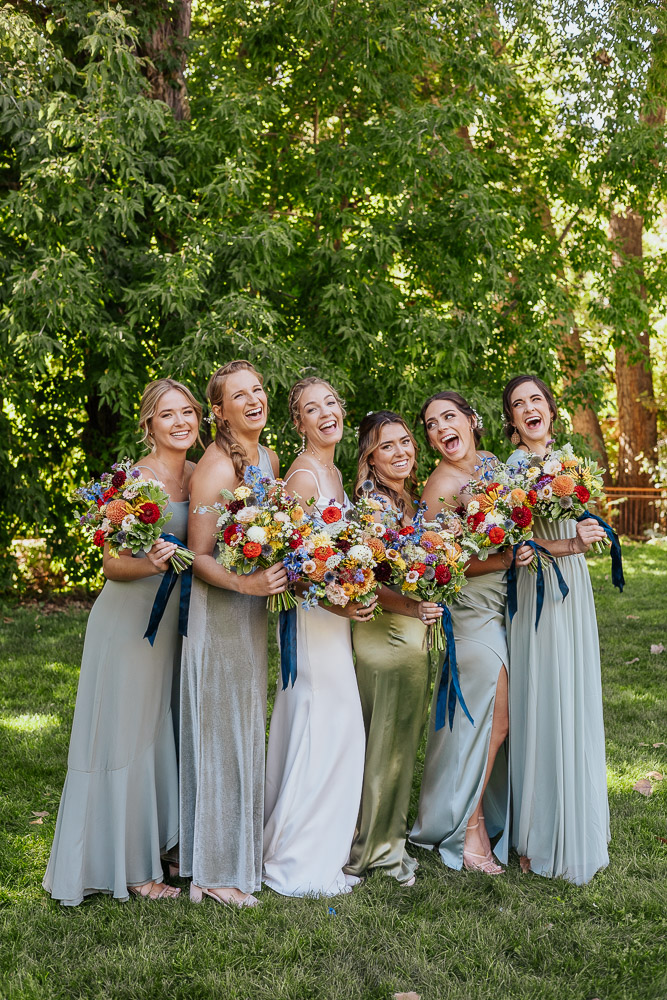 Bride and bridesmaids laughing and enjoying each other’s company on the wedding day at Lyons Farmette.