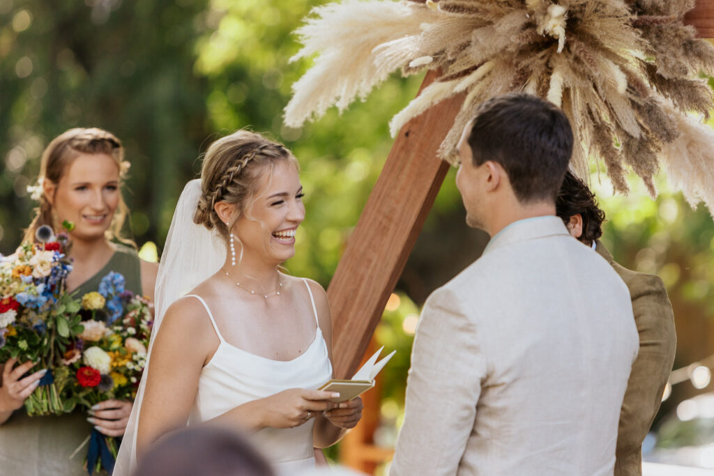 Bride smiling while reciting her vows during the wedding ceremony at Lyons Farmette.