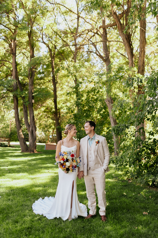 Bride and groom share a joyful moment before their ceremony at a scenic Colorado venue.