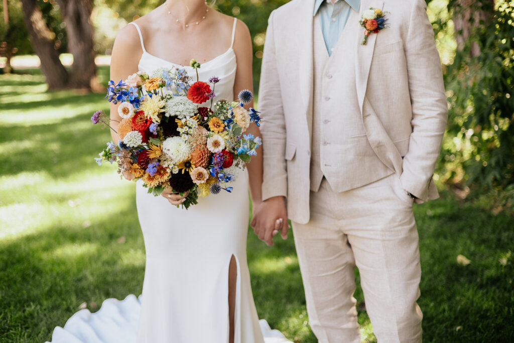 Detailed shot of the bride and groom’s wedding attire in a scenic garden setting at Lyons Farmette.