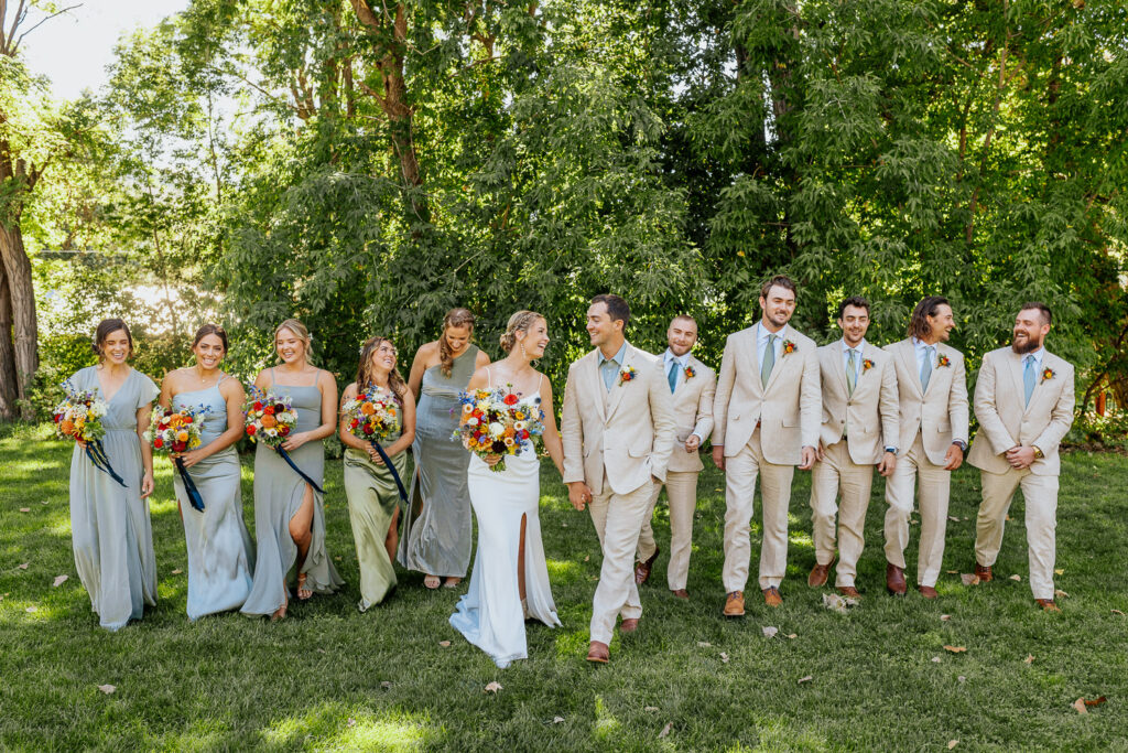 Bridal party walks towards the camera, showcasing the joy of the celebration at a scenic Colorado venue.