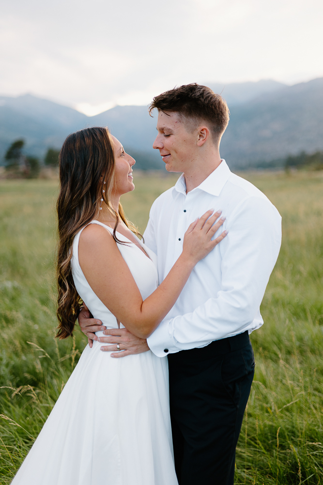 A joyful bride and groom gaze at each other lovingly during their Colorado mountain wedding photography session.