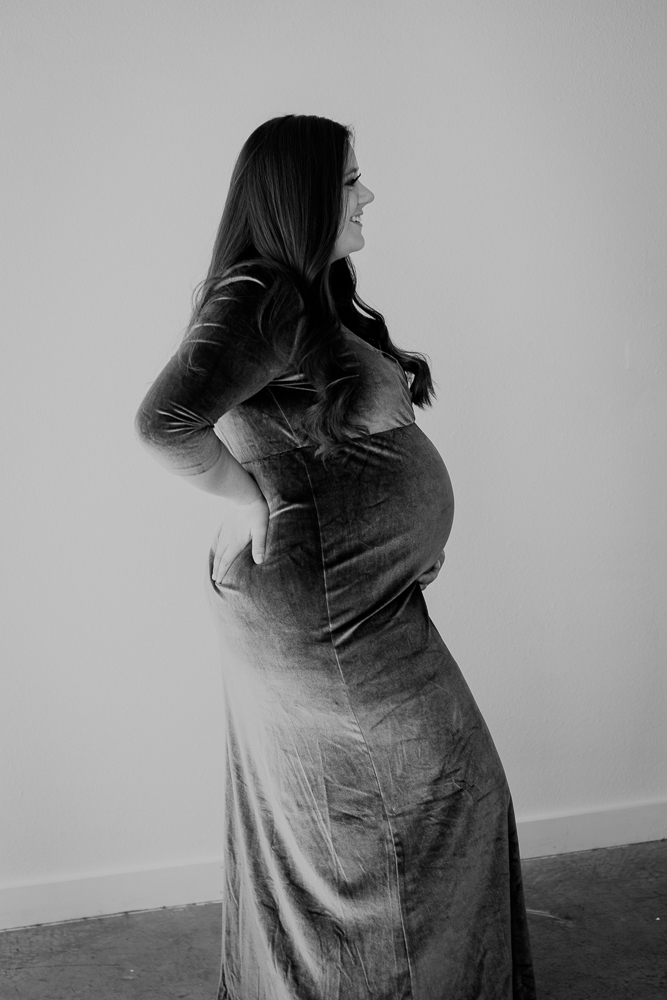 A black and white maternity portrait captured in Sugarhill Studio, emphasizing the intimate moments of pregnancy in a cozy, private setting.