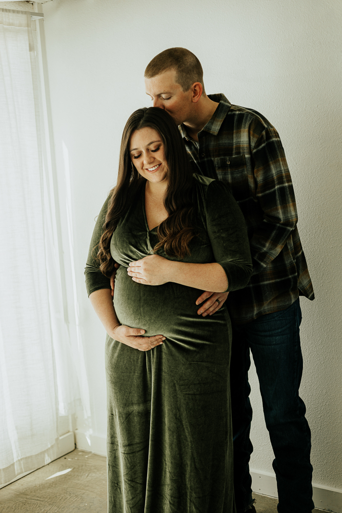 A tender maternity portrait of an expecting couple embracing at Sugarhill Studio, capturing their love and excitement for the baby on the way.