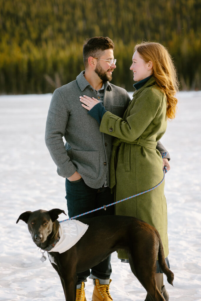 A bride and groom pose for a photo with their dog at Echo Lake in Colorado.