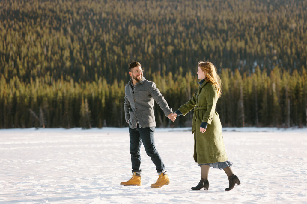 A couple walks along Echo Lake holding hands.