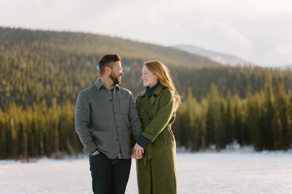 A couple holds hands and looks at eachother during their engagement session in Denver, Colorado.