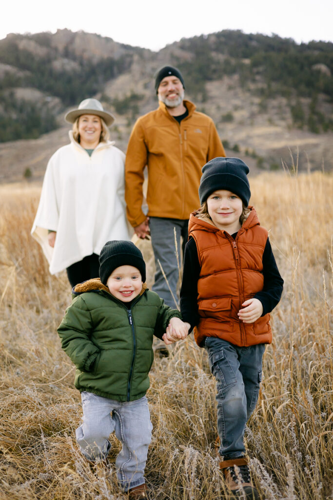 Two young boys walk towards the camera in front of their parents in Lory State Park.